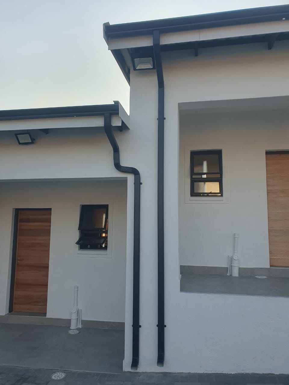 Gutter and downpipe system completed along a property boundary wall